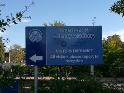 Photograph of Thurston CE Primary Academy Road sign with directions for visitors