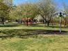 New Green's open space, showing grass, play equipment and the youth shelter