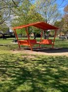 The youth shelter; an orange metal shelter with benches
